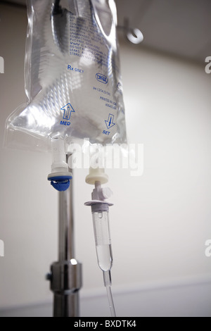 An IV bag on a pole connected to an IV line. Stock Photo