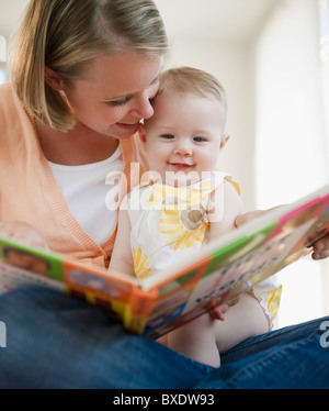 Mother reading book to her baby daughter Stock Photo