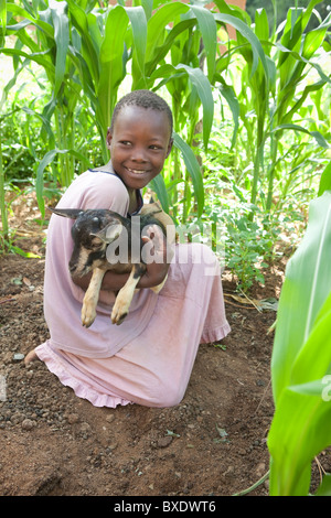 Eight year old Janet Ngasha holds a small goat in Dodoma, Tanzania, East Africa. Stock Photo