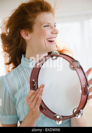 Woman playing tambourine Stock Photo