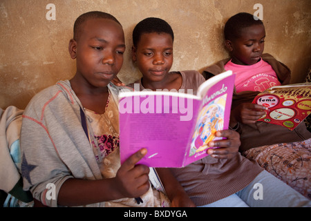 Adolescent girls read together at an after school program in Iringa, Tanzania, East Africa. Stock Photo