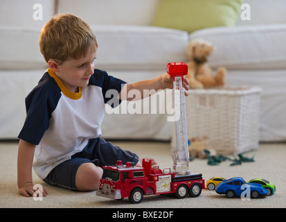 Young boy playing with toy fire truck Stock Photo