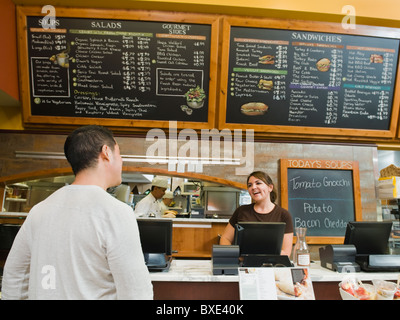 Cashier smiling behind bakery counter Stock Photo: 55534238 - Alamy