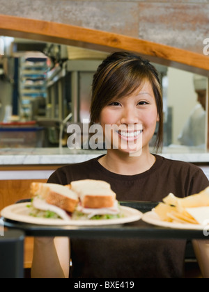 Woman holding tray of food Stock Photo