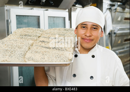 Chef holding tray of bread Stock Photo