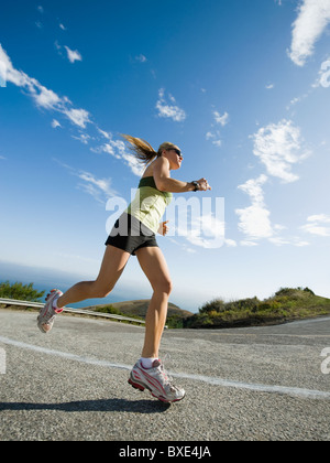 Woman running on a road in Malibu Stock Photo