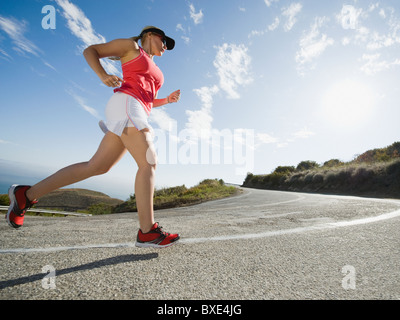 Woman running on a road in Malibu Stock Photo