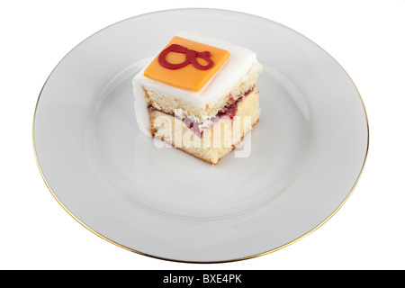 Portion of Iced jam and cream filled sponge cake on a white plate Stock Photo
