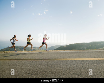 Runners training on side of a road Stock Photo