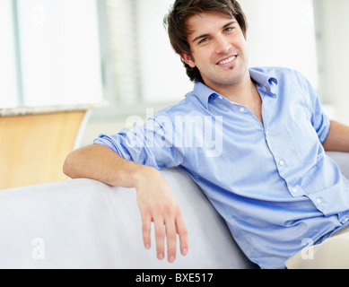 Handsome man sitting on couch Stock Photo