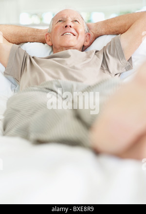 Relaxed senior man lying on bed Stock Photo