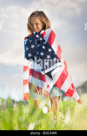 Young girl draped in American flag Stock Photo