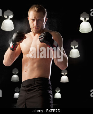 Cage fighter wearing boxing gloves Stock Photo