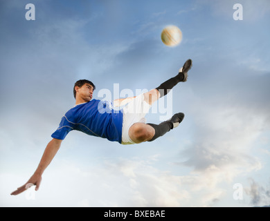 Soccer player kicking ball Stock Photo