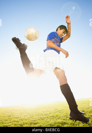 Soccer player jump kicking Stock Photo