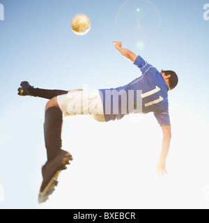 Soccer player jump kicking Stock Photo