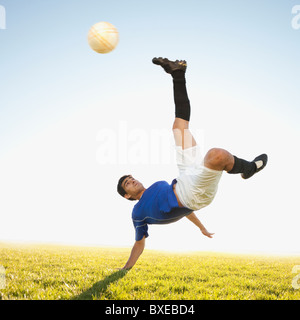 Soccer player jump kicking Stock Photo