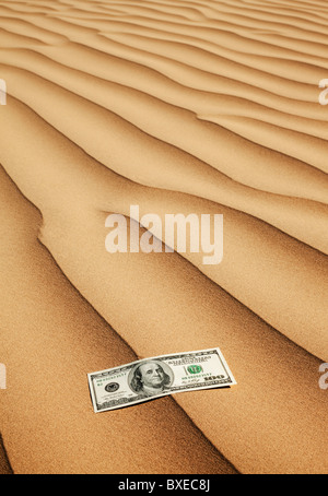 100 dollar bill on sand in desert Stock Photo