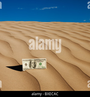 100 dollar bill on sand in desert Stock Photo