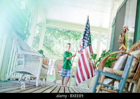 Young boy carrying American flag Stock Photo