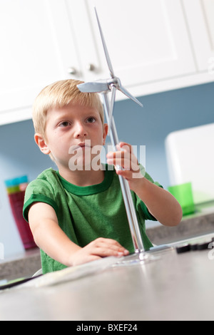 Little boy looking at model windmill Stock Photo