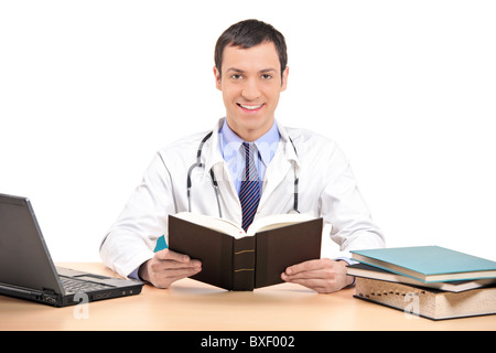 A medical doctor posing in his office, with laptop and many other books Stock Photo