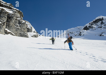 Two free skiers climbing up a snowy mountain side near Narvik, Norway Stock Photo