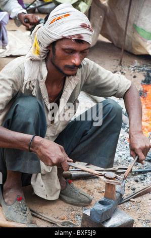 Gadia Lohar. Nomadic Rajasthan man forging axe heads. India's wandering blacksmiths Stock Photo