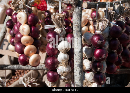 Market plaits of onions and garlic hanging to dry Stock Photo