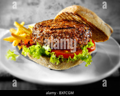 Peppered beef burger with chips and wholemeal bun Stock Photo