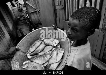 A displaced boy sells fish in the stilt house area in Tumaco, Nariño dept., Colombia. Stock Photo