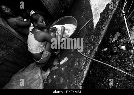 A displaced girl washes the clothes in the stilt house area in Tumaco, Nariño dept., Colombia. Stock Photo