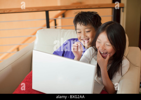 Mixed race brother and sister using laptop together Stock Photo