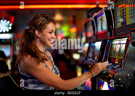 Caucasian woman playing slot machine in casino Stock Photo