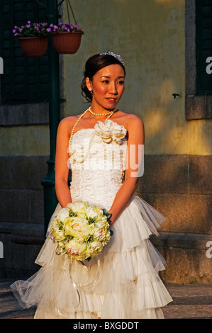 Full length portrait of ethnic bride with bouquet of flowers Stock Photo