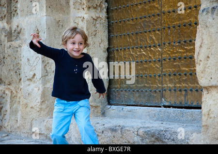 Little girl playing outside the Cathedral de Cordoba, a former medieval mosque in Cordoba, Andalusia, Spain. Stock Photo