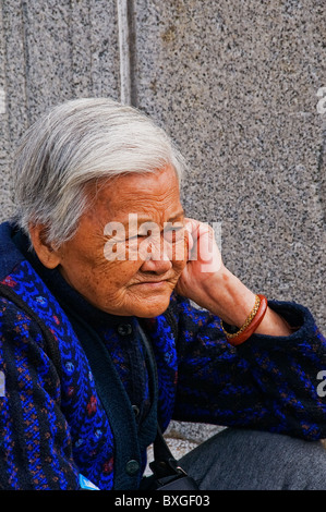 Expressive older Asian woman with head of full gray hair Stock Photo