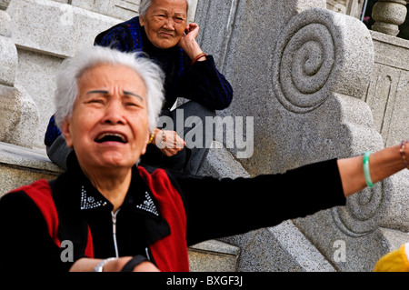 Upset expressive older Asian woman yelling Stock Photo