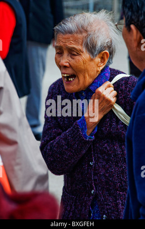 Expressive older Asian woman with head of gray hair Stock Photo