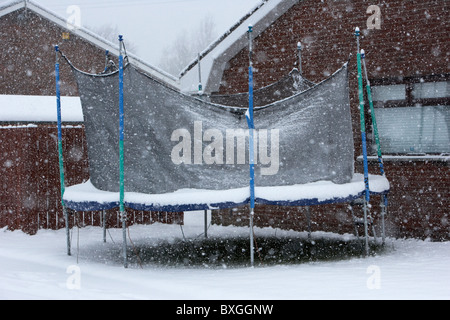 childrens trampoline covered in snow on a cold snowy winters day Belfast Northern Ireland Stock Photo