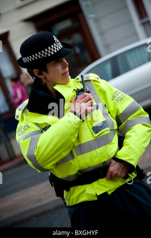 Uniformed UK female police officer in ready stance holding metal ...