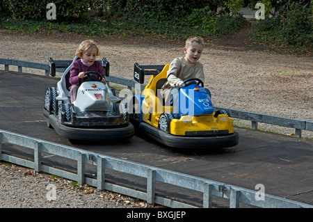 Two children speeding in go karts in an amusement park. Stock Photo