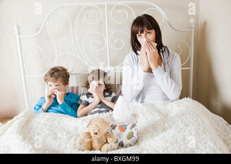 Mother and children sick in bed
