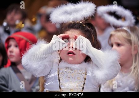 Children dressed as angels performing in a primary school christmas nativity play, UK Stock Photo