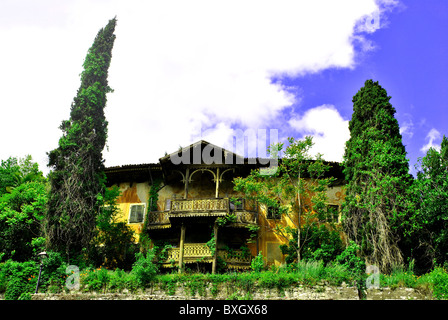 old palace of wood and style idiano surrounded by vegetation and cypress trees and in a state of neglect Stock Photo