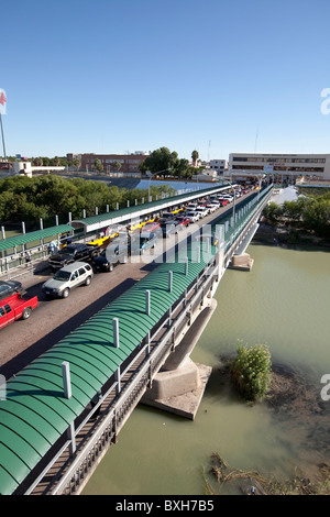 Cars headed from Mexico towards United States customs checkpoint in Laredo, Texas, wait on bridge over Rio Grande River Stock Photo