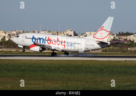 bmibaby Boeing 737-300 touching down on the runway at Malta International Airport Stock Photo