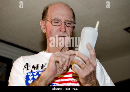 A senior Caucasian man placing a call dials on a cordless phone. USA. Stock Photo