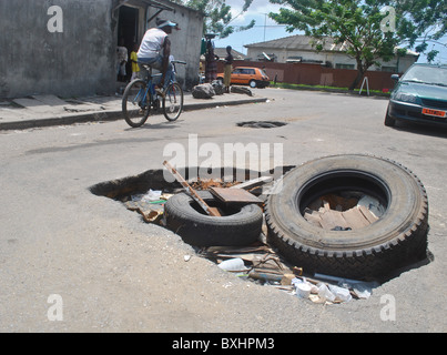 Giant potholes in a road in Abidjan, Ivory Coast Stock Photo