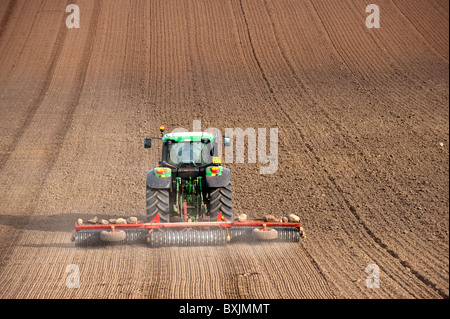 Farmer with soil press rolling seedbed, using John Deere tractor. Kelso ...